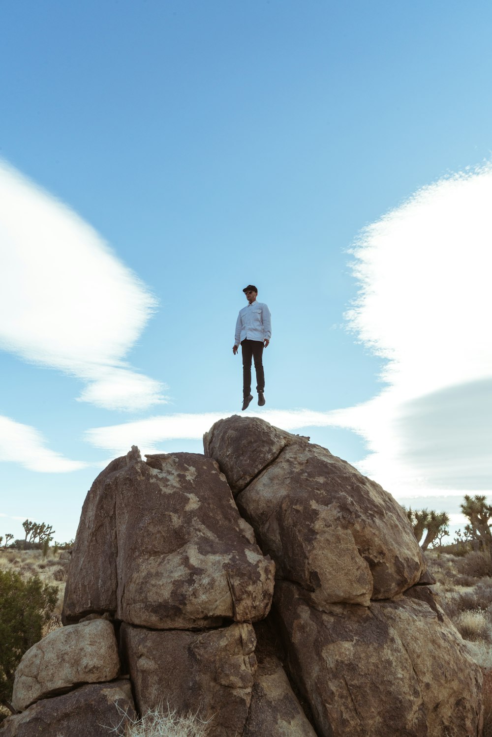 man jump on brown boulder