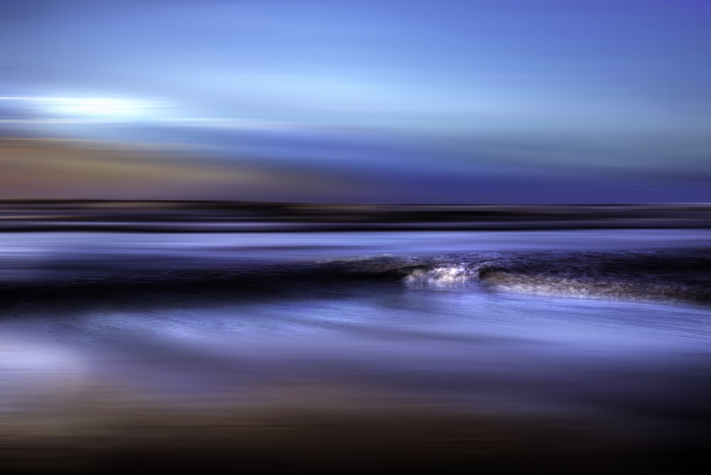 a blurry photo of a wave coming in to shore