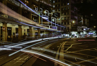 City streets at night illuminated by glowing car routes representing Urbanmais rides in motion.