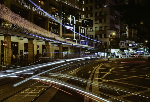 City streets at night illuminated by glowing car routes representing Urbanmais rides in motion.