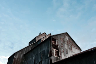 A robust steel shed covering large industrial equipment under a cloudy sky.