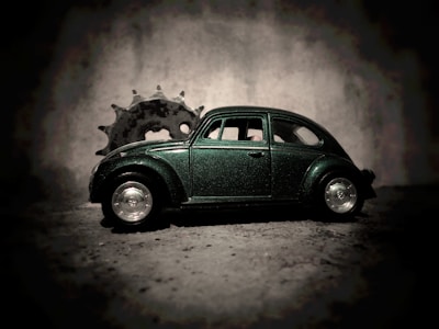 Close-up of elegant dark green and gold car parts arranged artfully on a black surface.