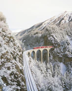 approaching red train across mountains
