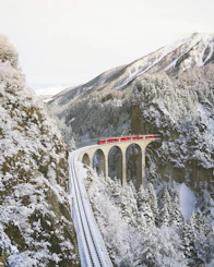 approaching red train across mountains