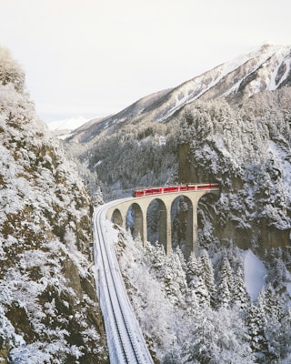 approaching red train across mountains