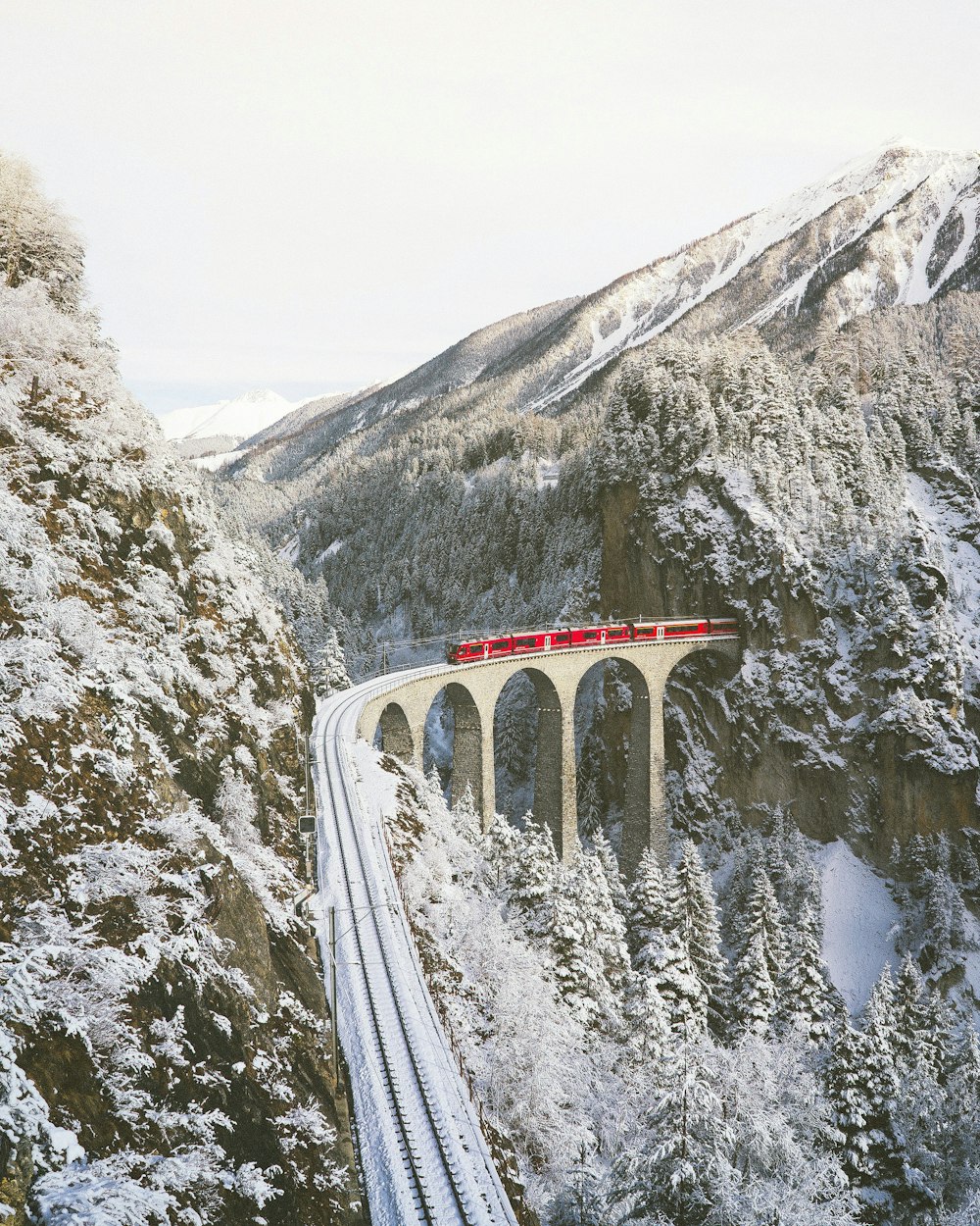 approaching red train across mountains