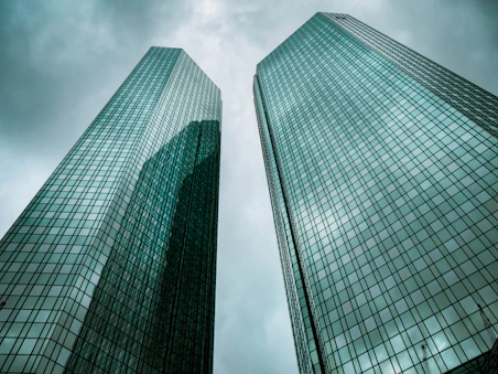 two high-rise buildings under gray clouds during daytime