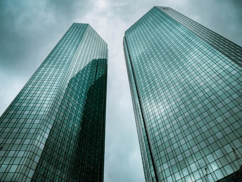 two high-rise buildings under gray clouds during daytime