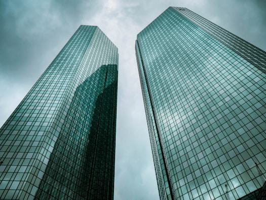 two high-rise buildings under gray clouds during daytime