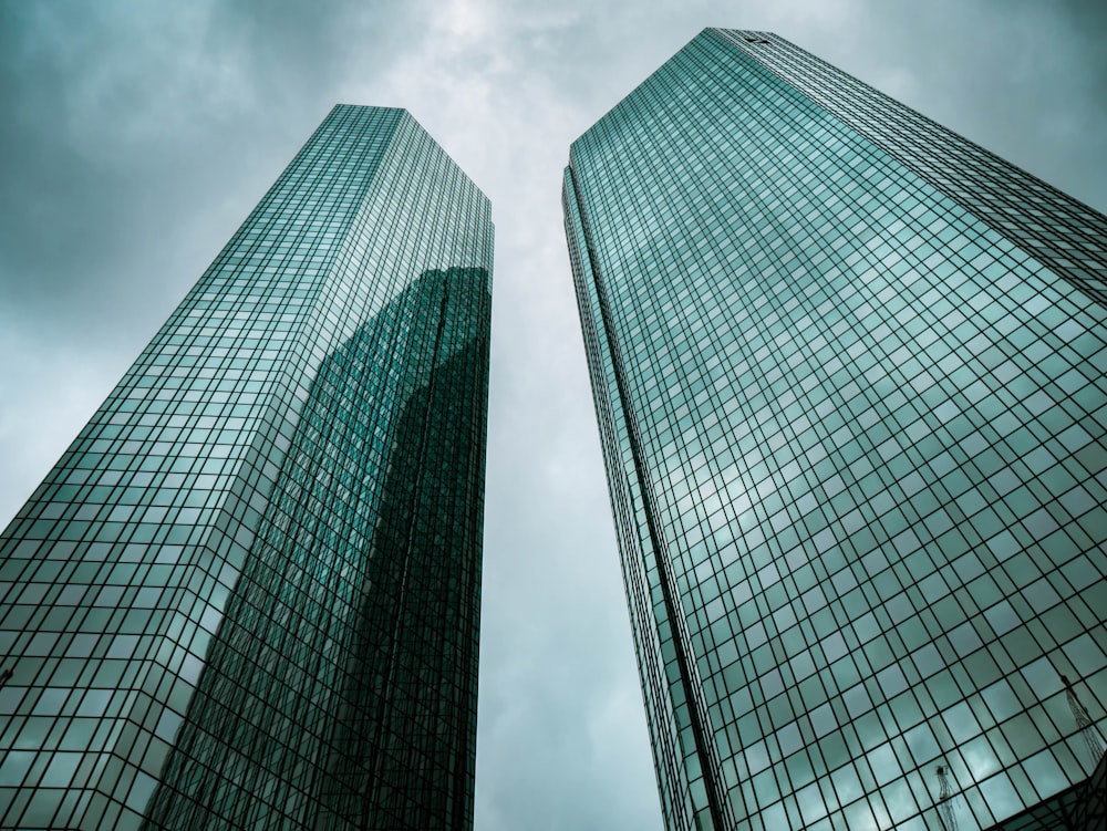 two high-rise buildings under gray clouds during daytime