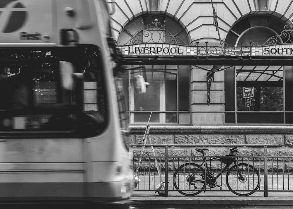 grayscale photography of bicycle parked at steel fence