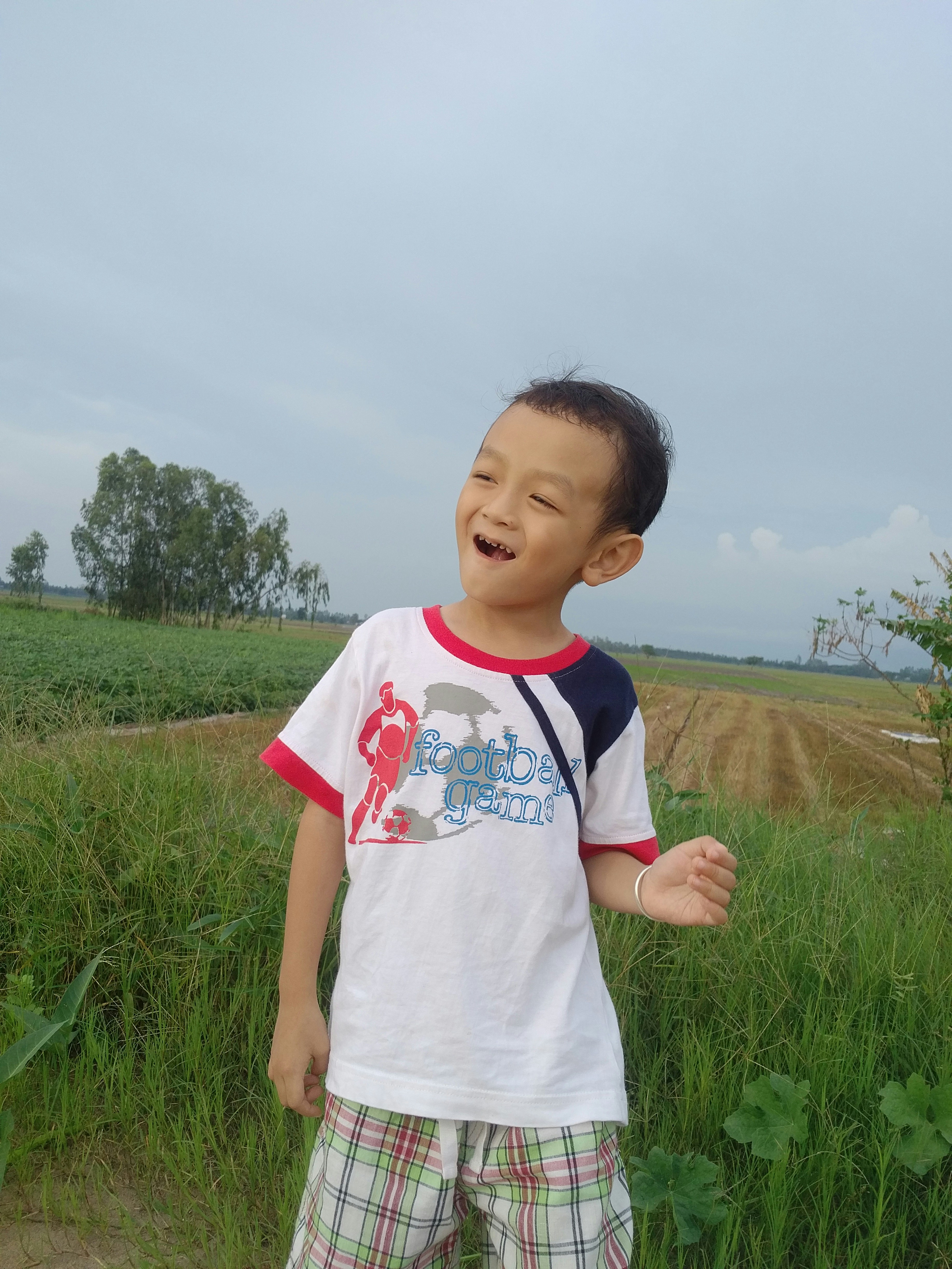 Niño joven sonriendo con expresión entusiasta en espacio abierto