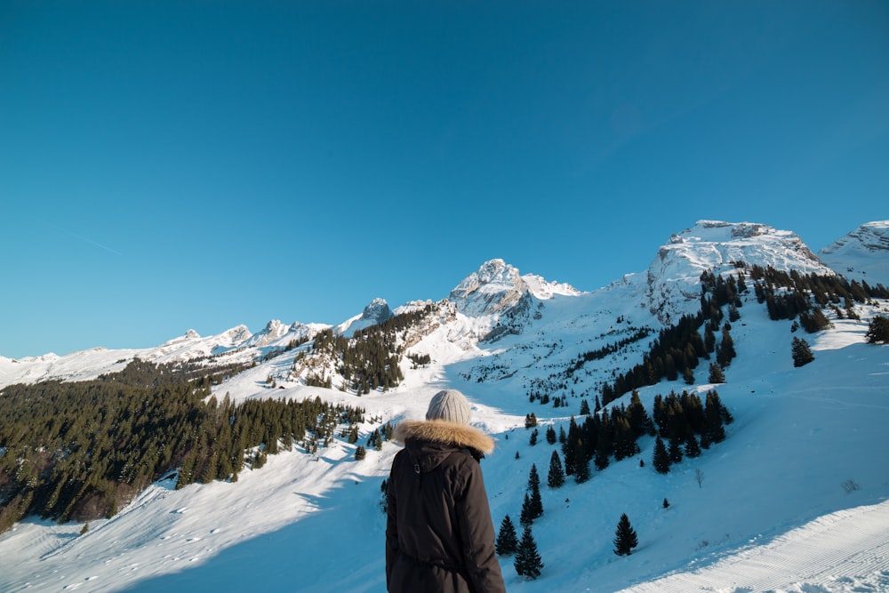 Person, die in der Nähe eines schneebedeckten Berges steht