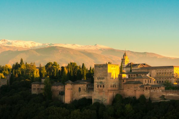 Beige castle within mountain range — Granada, Spain