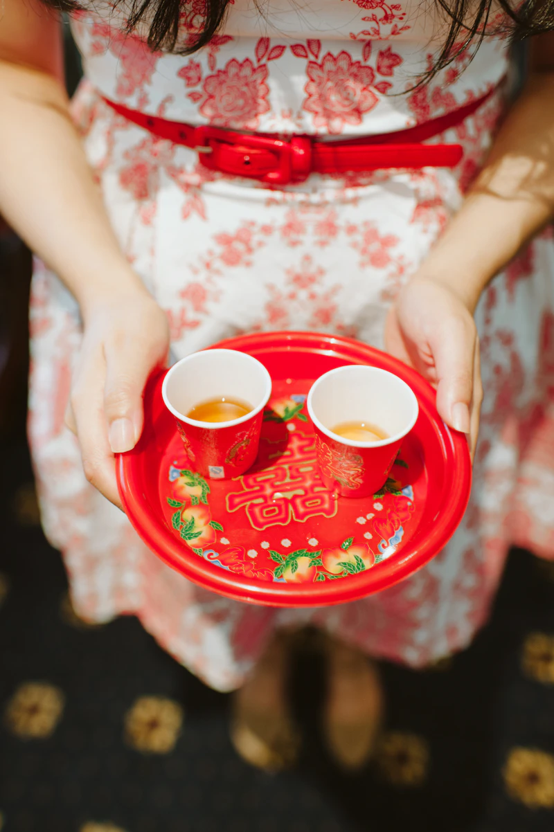 Hands holding red tea cups in tea ceremony
