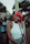 Close-up of a joyful woman wearing a curly, vibrant red wig outdoors