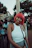 Close-up of a joyful woman wearing a curly, vibrant red wig outdoors
