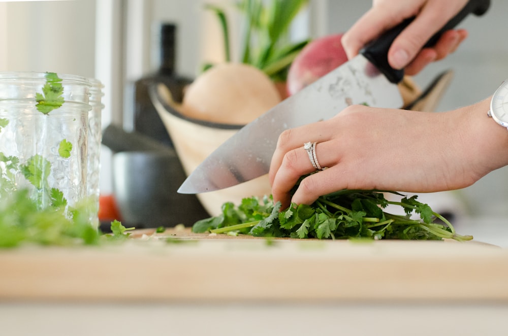 person cutting vegetables with knife