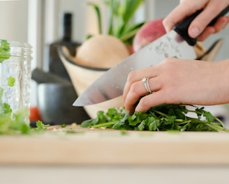 person cutting vegetables with knife