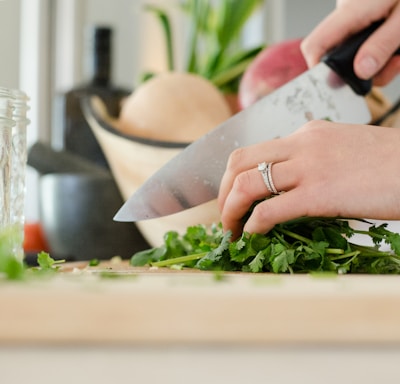 person cutting vegetables with knife