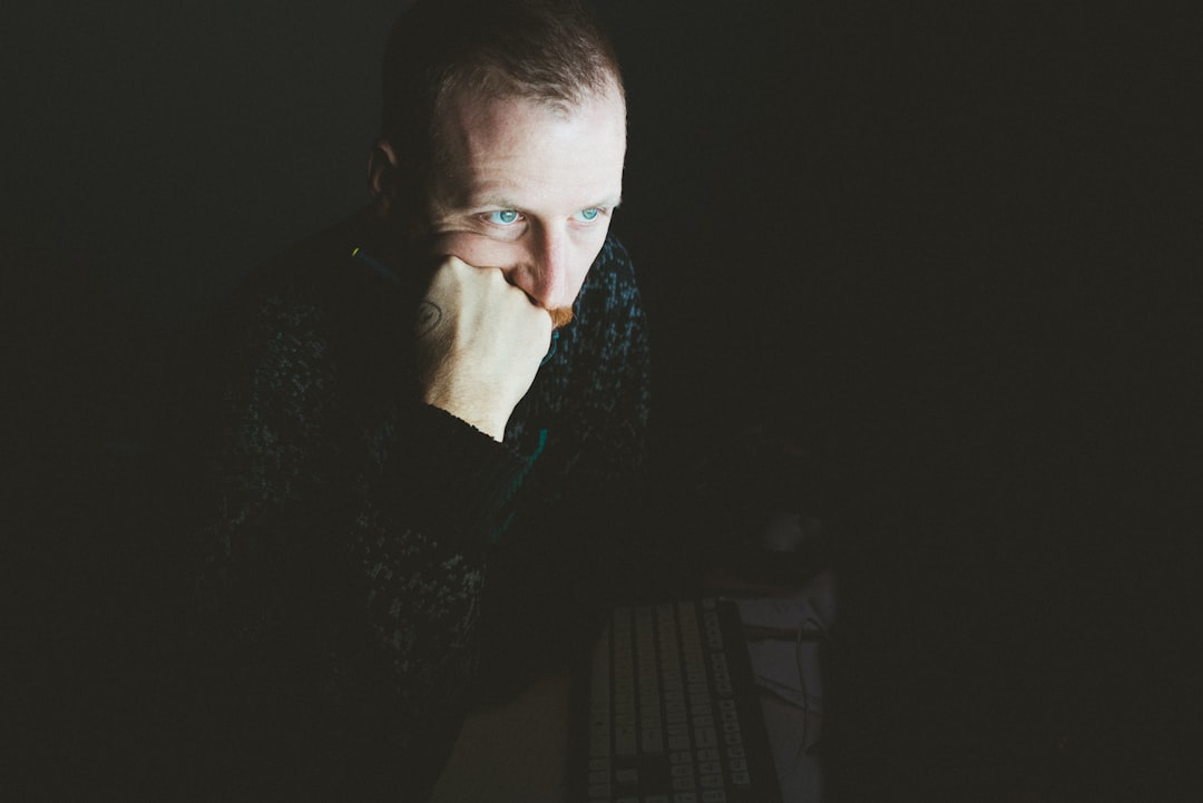 low light photography of man in gray sweater