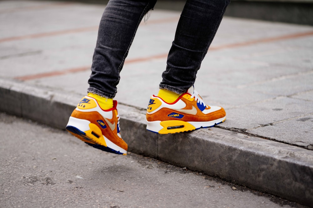 Foto Persona que lleva un par de zapatillas Nike Air Max de caña baja  naranjas y blancas – Imagen Moda gratis en Unsplash