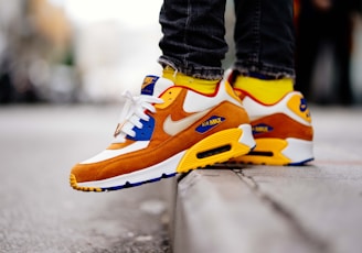 close-up photography of person wears brown-and-white Nike Air Max