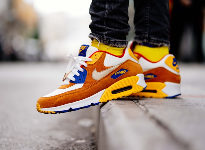 close-up photography of person wears brown-and-white Nike Air Max