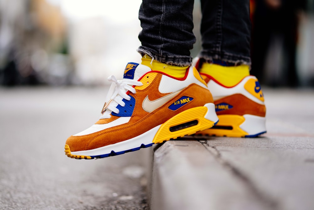 close-up photography of person wears brown-and-white Nike Air Max