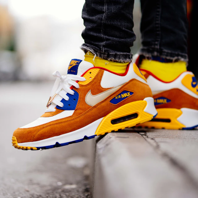Close up of a person on an Athens street wearing brown and white Nike Air Max 90 sneakers