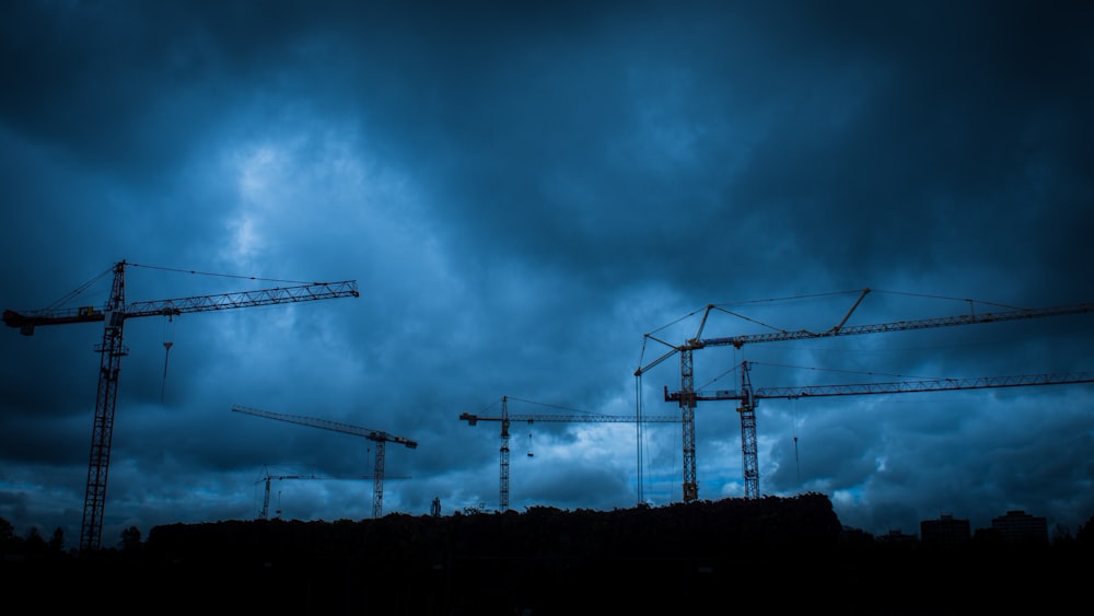 metal crane towers during cloudy day