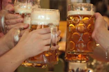 Close-up of frothy beer glasses clinking in a celebratory toast on the moving beer bike.