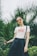 woman standing behind palm plants