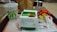 A McDonald's meal consisting of a large drink cup, a box containing a McSpicy Paneer burger, and a packet of fries partially opened. The items are placed on a tray with table condiments like ketchup packets. The setting is a fast-food restaurant with a modern interior design.
