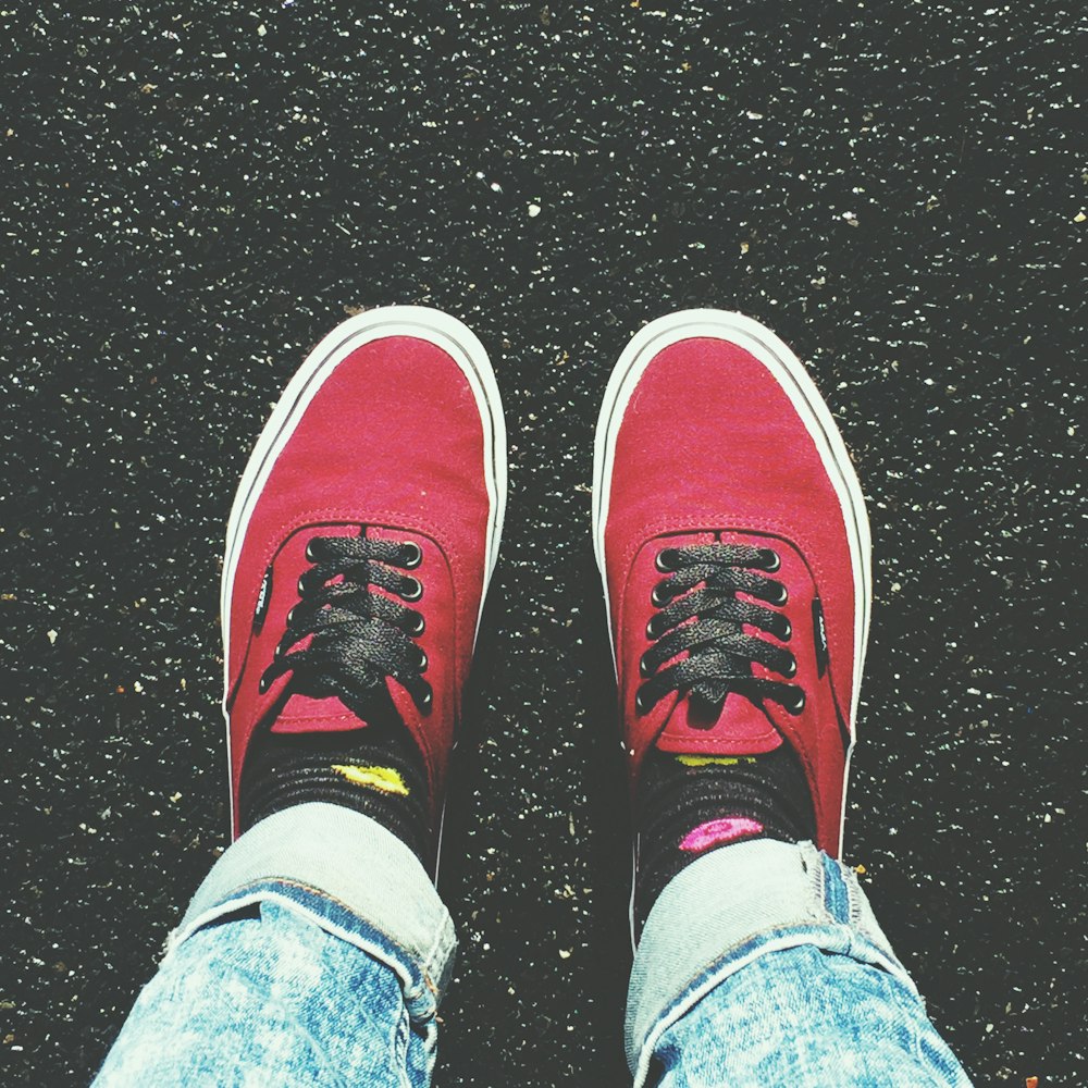 person in blue denim jeans and red and white sneakers