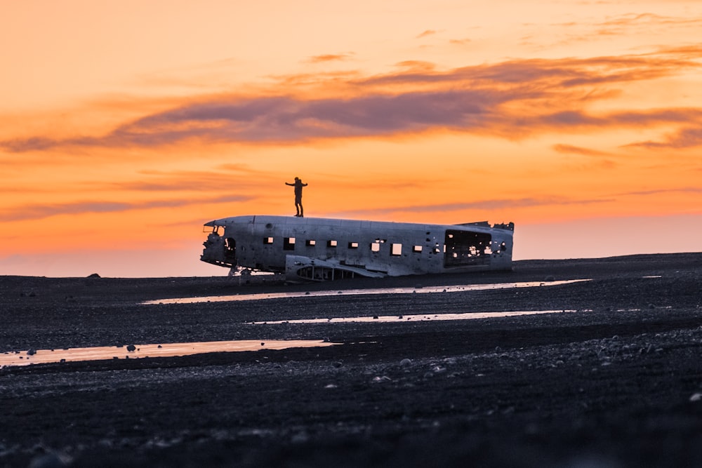 wrecked airplane on ground under clouds during golden hour