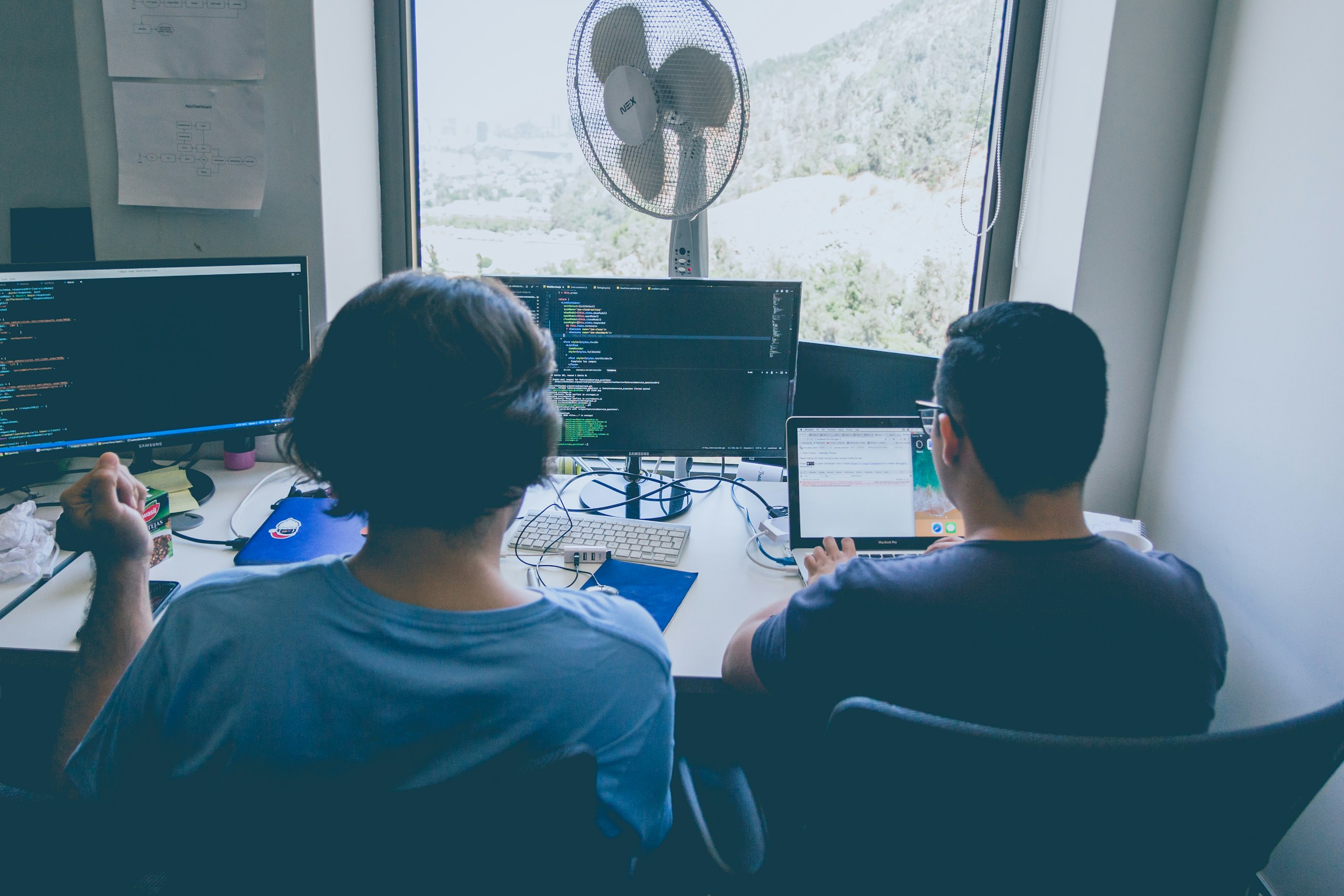 two men using computer and laptop