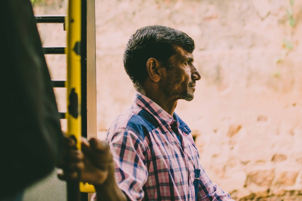 selective focus photo of man holding yellow pole