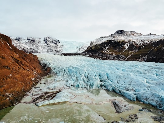 frozen river in the middle of rock mountains in Skaftafell Iceland