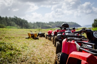 focus photography of ATV's falling in line on grass field