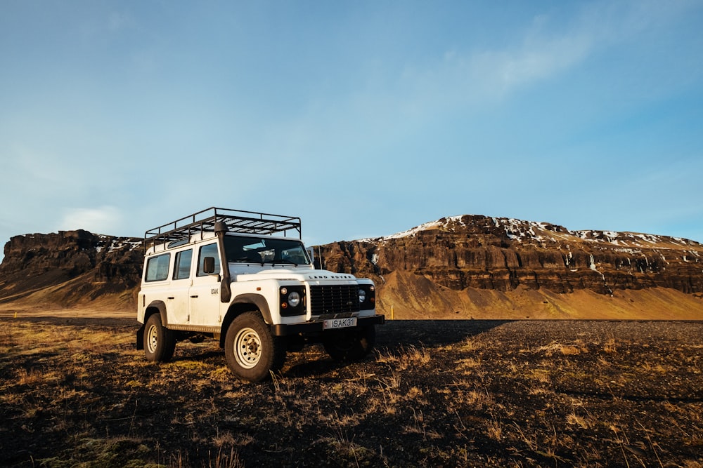 Jeep Wrangler blanche près de la montagne brune pendant la journée