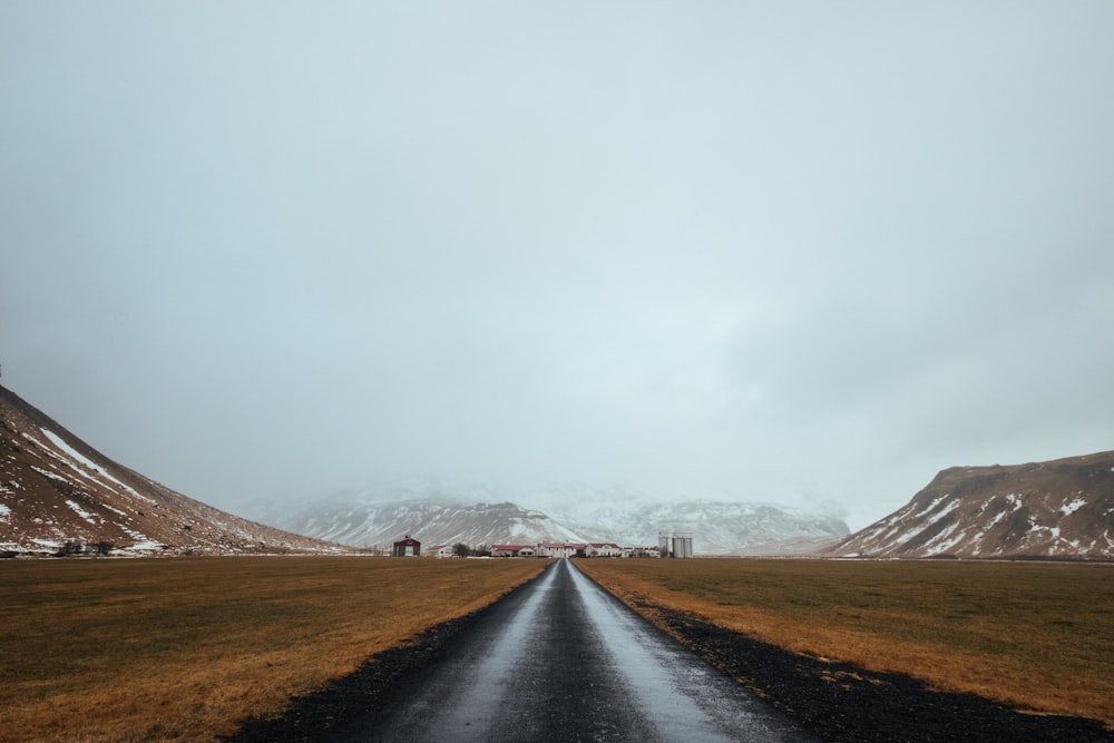 Carretera pavimentada gris cerca de la montaña durante el día