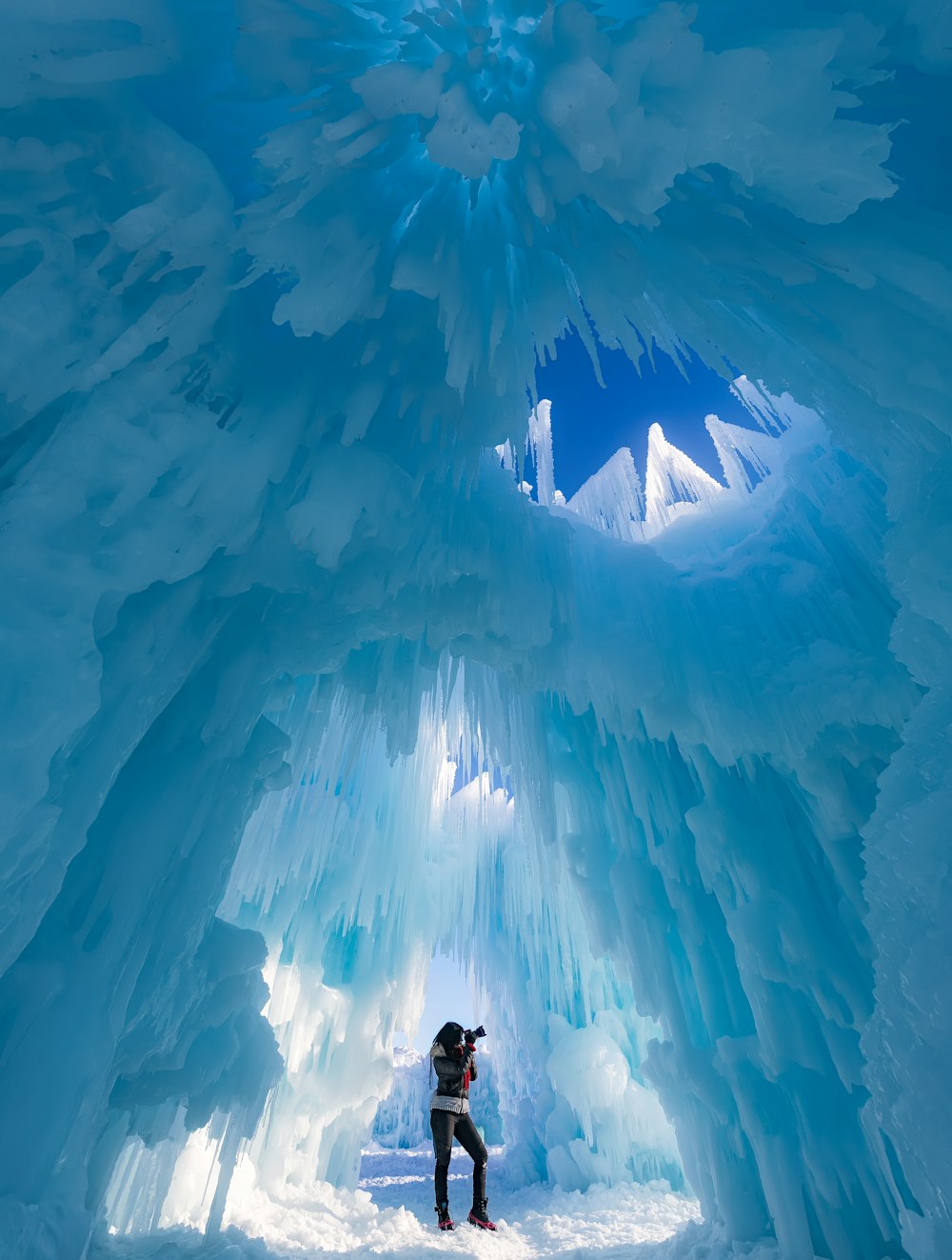 氷の洞窟で写真を撮る女性