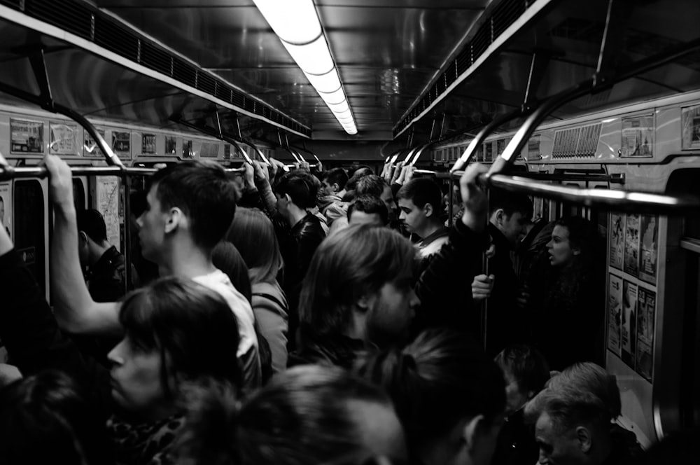 기차를 타고 있는 사람들의 회색조 사진