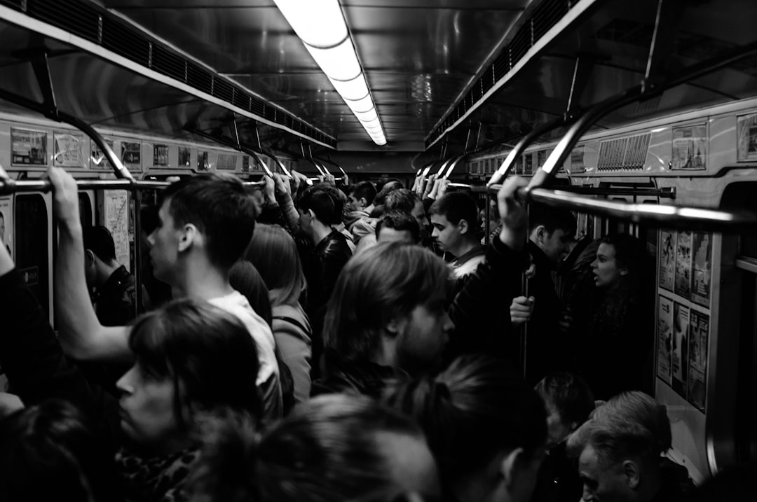 grayscale photography of people riding train,