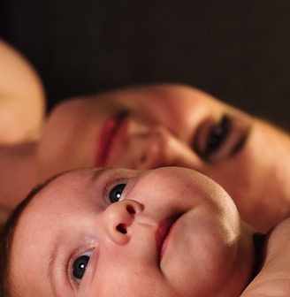 shallow focus photography of baby beside woman