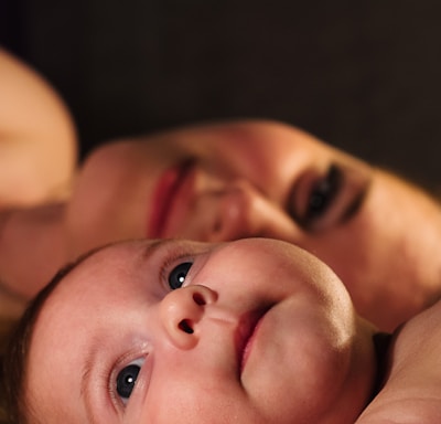 shallow focus photography of baby beside woman