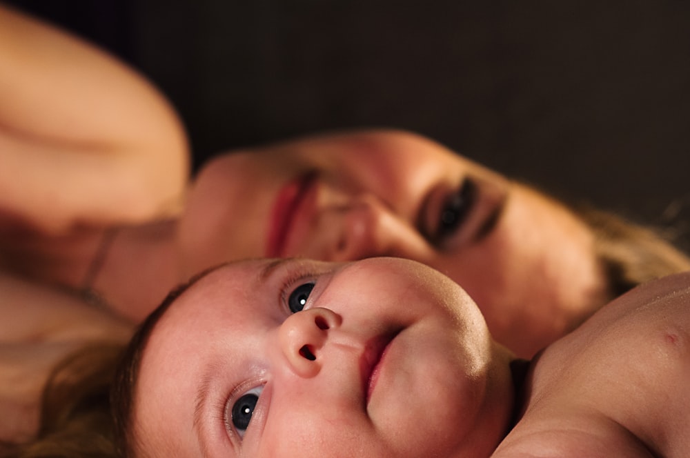여자 옆에 있는 아기의 얕은 초점 사진