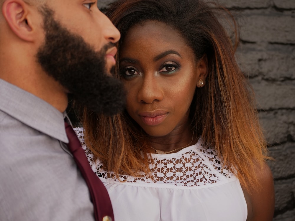 woman wearing white shirt beside man wearing grey shirt and necktie