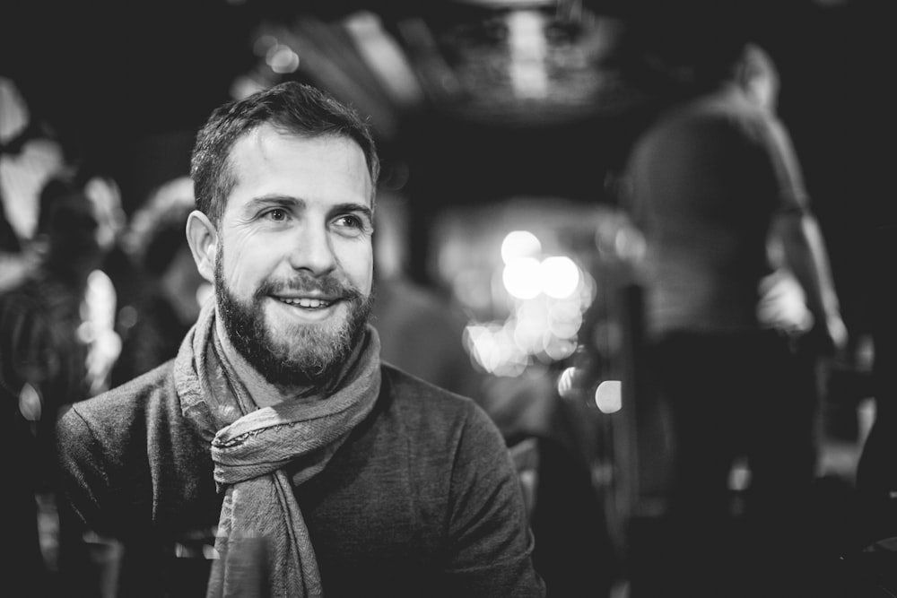 grayscale photography of man with scarf